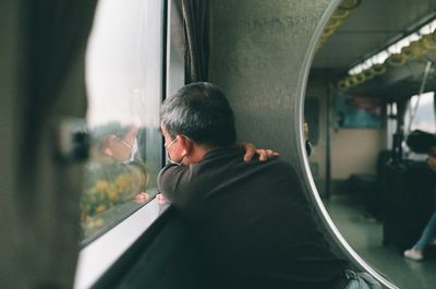 man looking out the train window