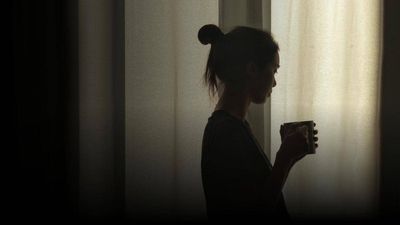 woman by a window with a mug.